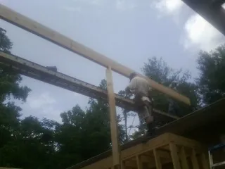 Carpenter setting a ridge beam over a new addition frame — Ice Dam Removal by Roofing Brothers in Plainsboro