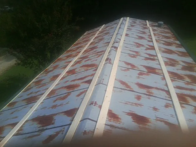 Rusted metal roof panels with new wood purlins before replacement — Storm Damage Roof Repair in Plainsboro by Roofing Brothers