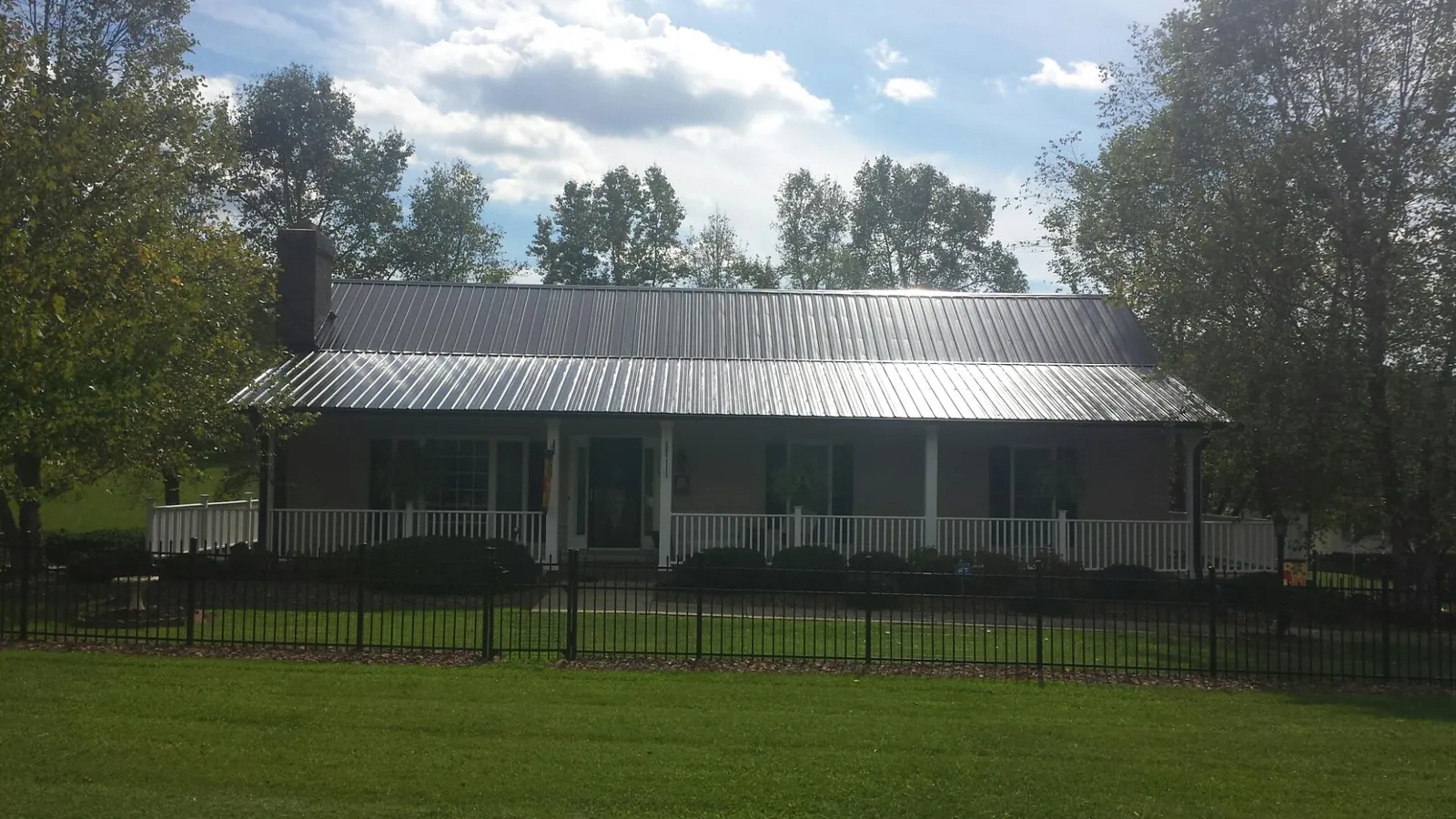 Gray metal roof on a brick ranch with a full width front porch — Gutter Guard Installation work by our crew in Plainsboro