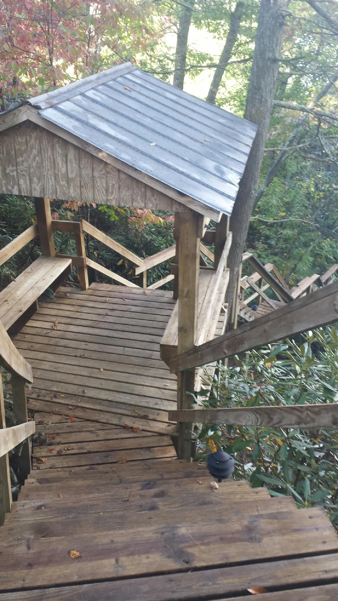 Metal roofed shelter over wooden steps on a wooded walkway — Skylight Repair & Installation work by our crew in Plainsboro