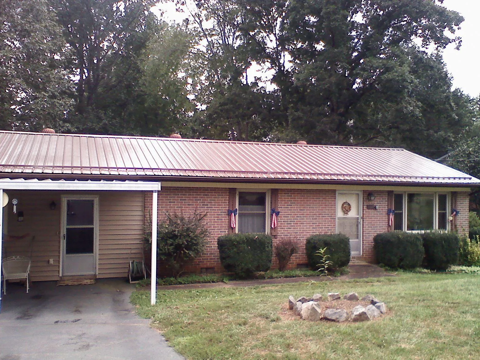 Bronze metal roof and carport on a brick ranch home — Roof Repair work by our crew in Plainsboro